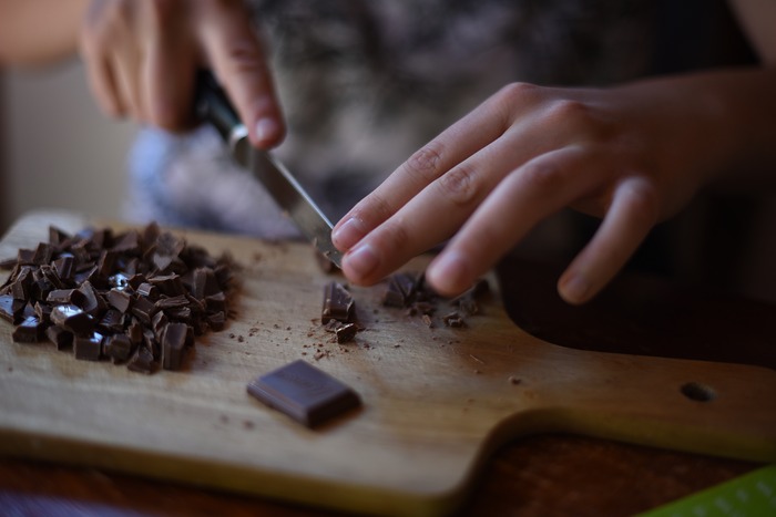 Une personne coupe du chocolat en pépites